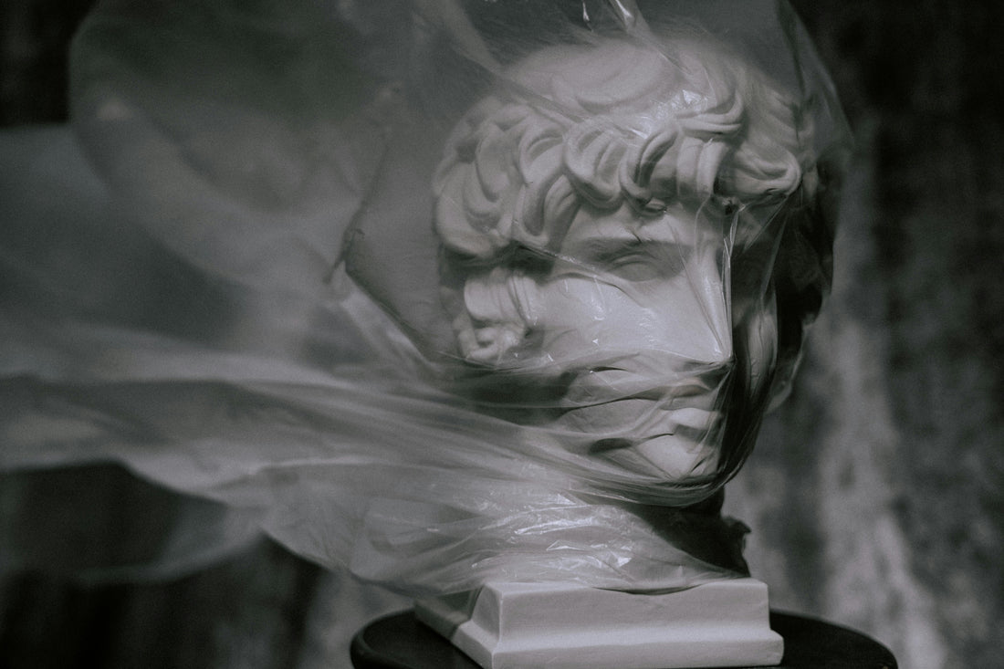Plastic sheet covers the face of a statue | Vearthy