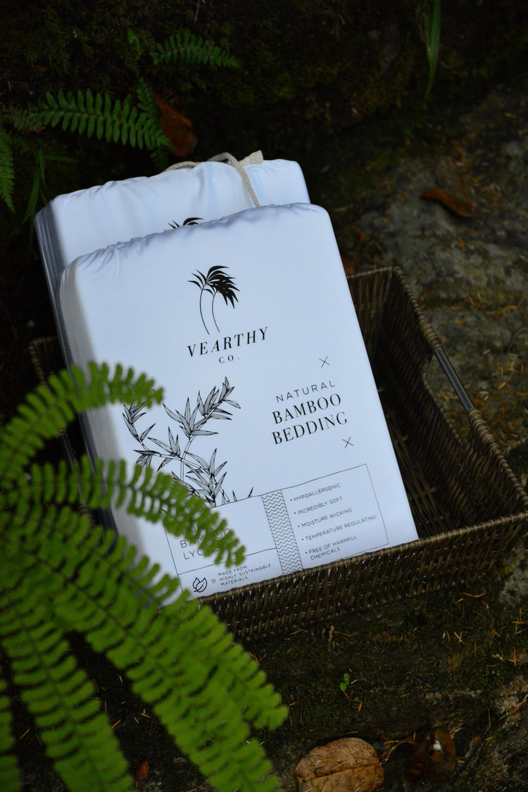 Bamboo lyocell bedding from Vearthy sit in a basket, surrounded by a natural background of fauna.