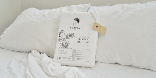 Crisp white vearthy bedding sits on a cozy bed with white bedding