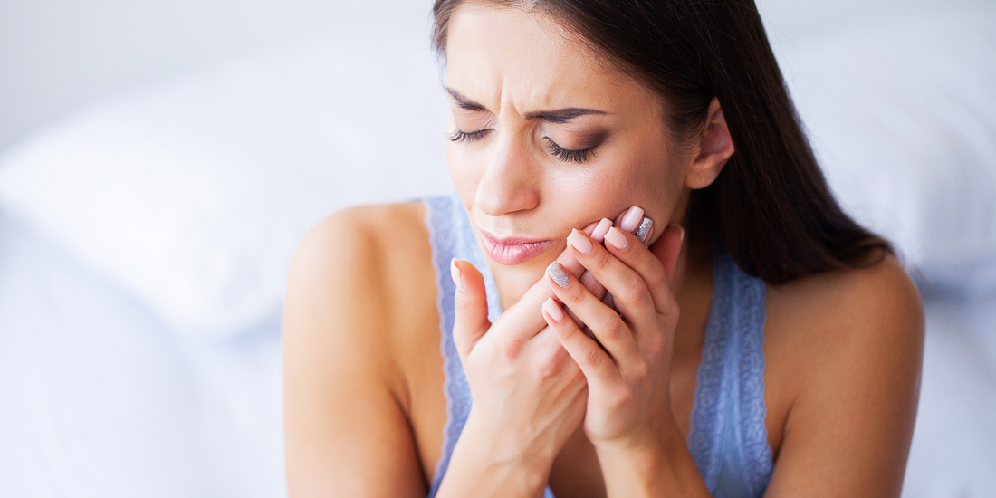Girl holding sore mouth from gum pain Vearthy.com