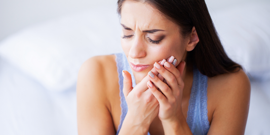 Girl holding sore mouth from gum pain Vearthy.com