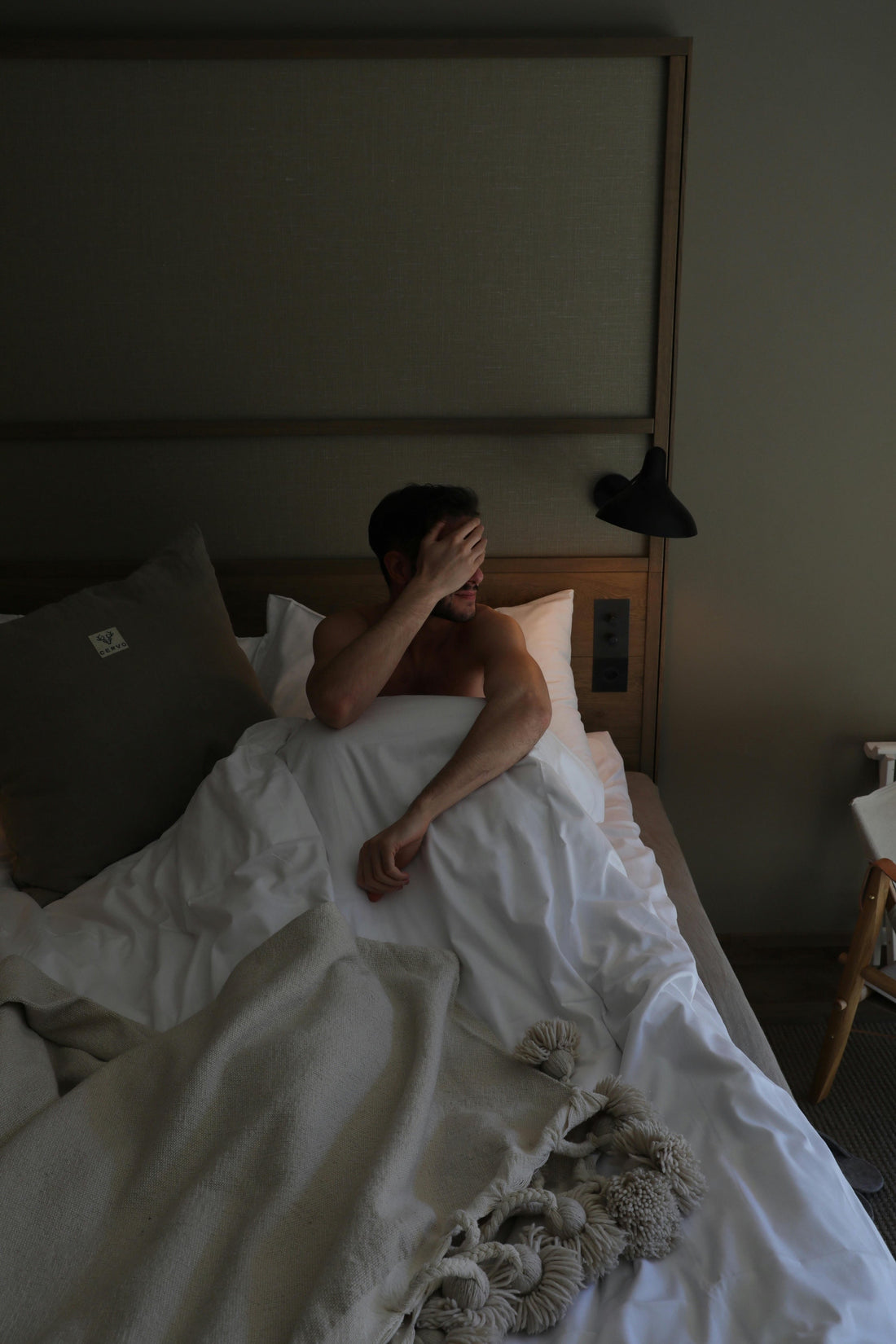 Man sitting up in bed sweating with face covered | Vearthy.com