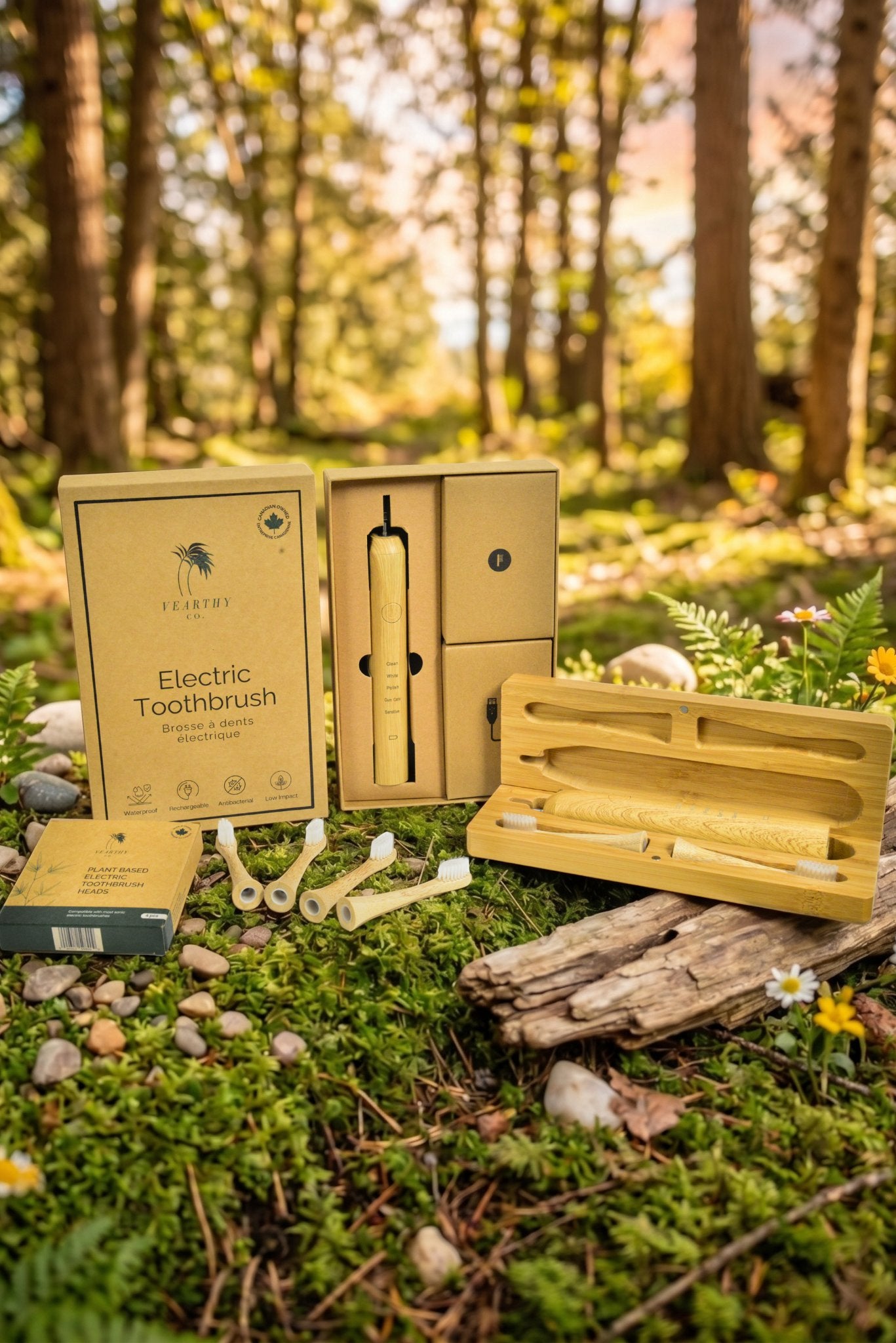 Vearthy bamboo sonic electric toothbrush starter kit with travel case, replacement heads and packaging on a mossy forest floor