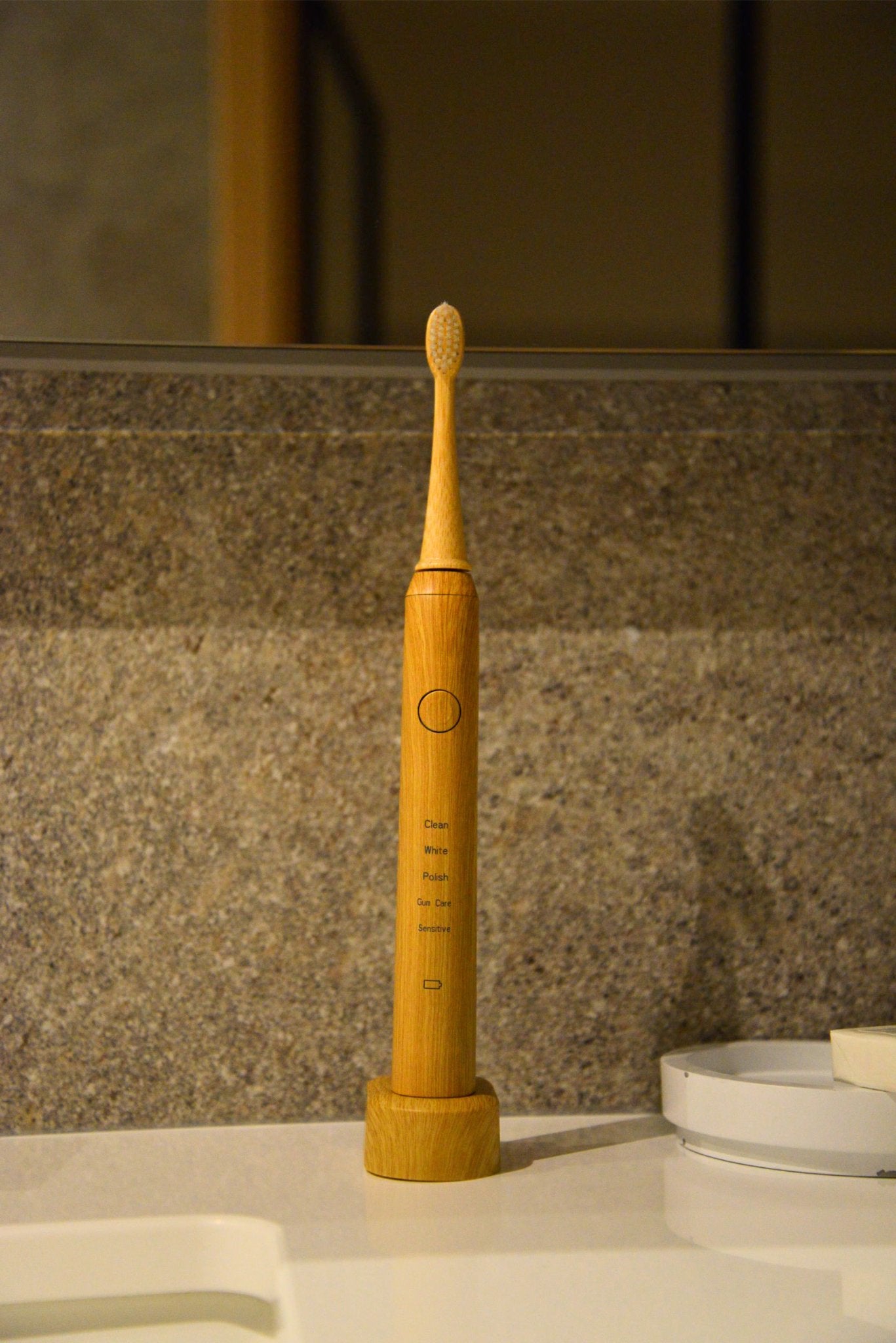 Vearthy bamboo sonic electric toothbrush on its charging stand on a bathroom counter