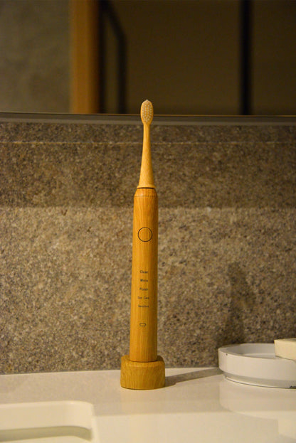 Vearthy bamboo sonic electric toothbrush on its charging stand on a bathroom counter