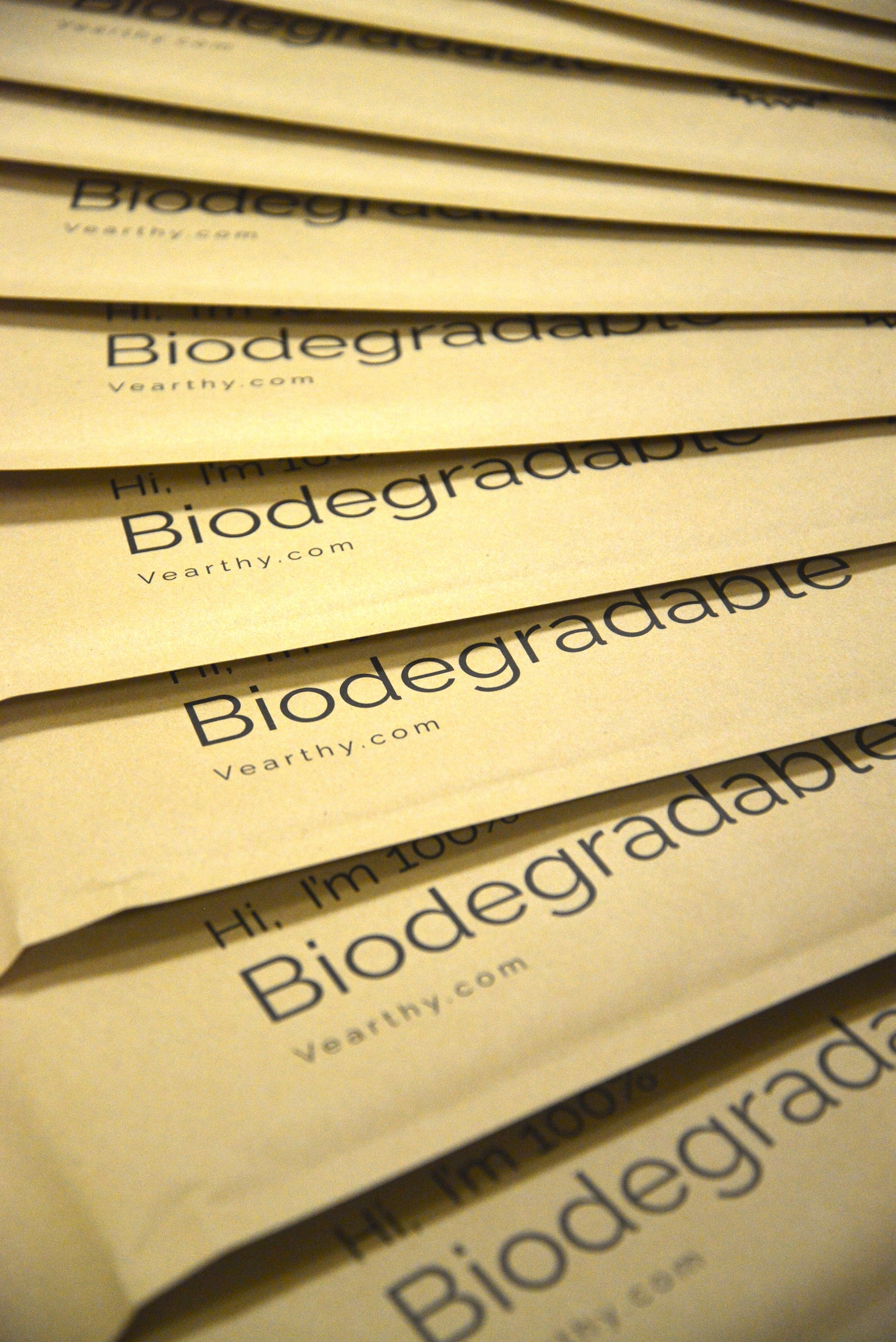 a stack of Vearthy Compostable Mailers fanned out on the ground