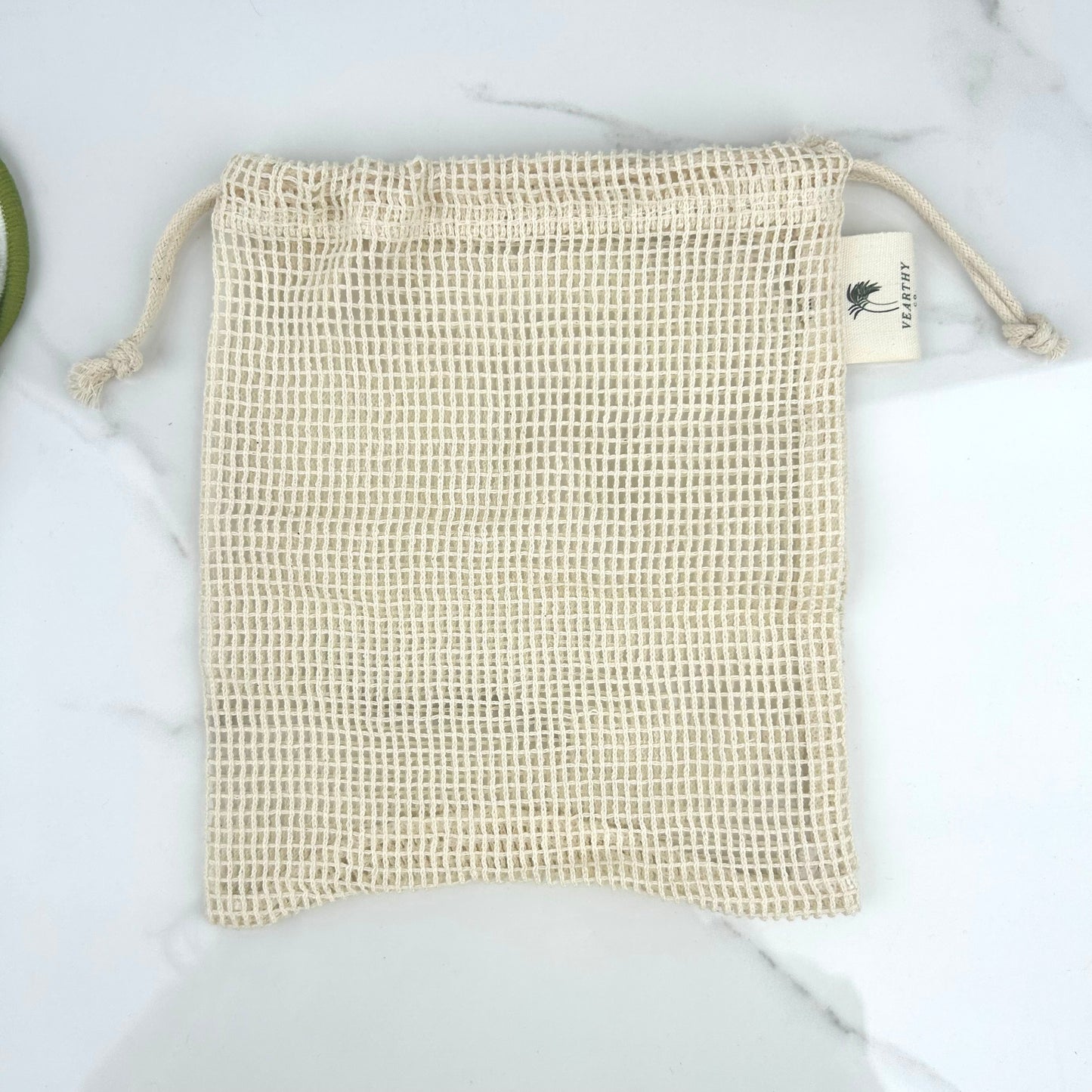 Vearthy beige mesh drawstring laundry bag on a light background