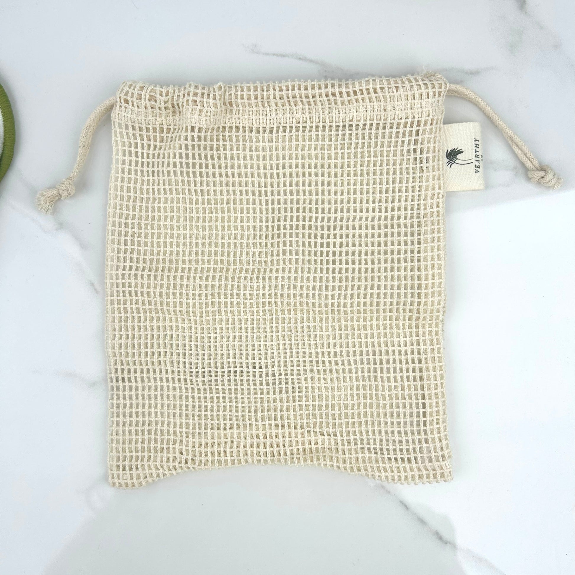 Vearthy beige mesh drawstring laundry bag on a light background