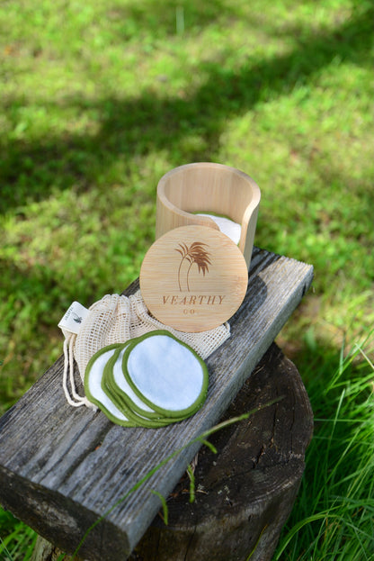 Vearthy bamboo cotton face pads sitting on weathered log, with included bamboo holding case and laundry bag