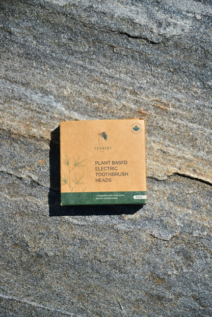 Vearthy cardboard packaging box with English text for plant based electric toothbrush heads on a grey stone
