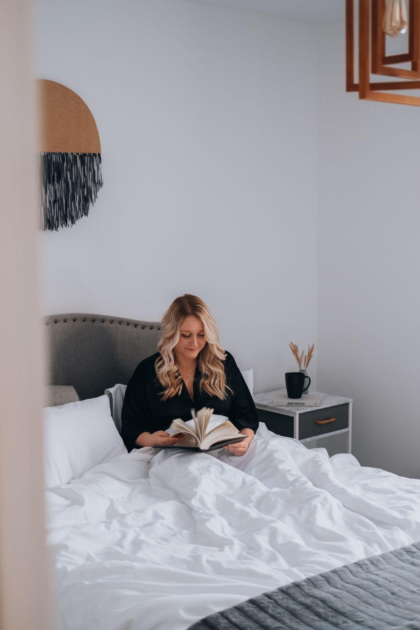 comfortable bed in minimalistic room with white sheets