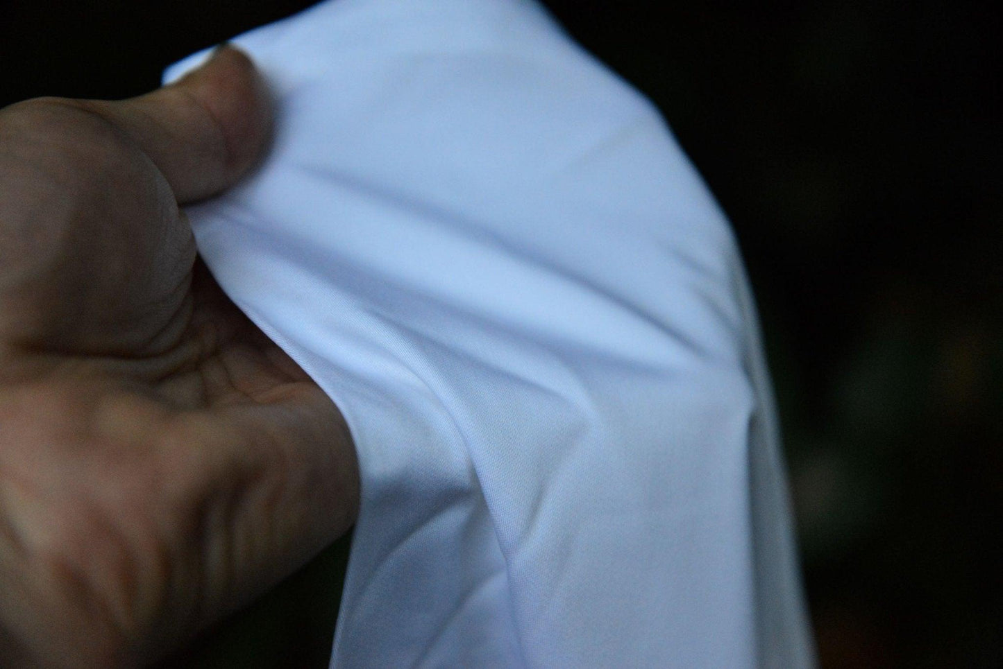 Close up of bamboo fabric in hand. It looks incredibly soft and smooth.